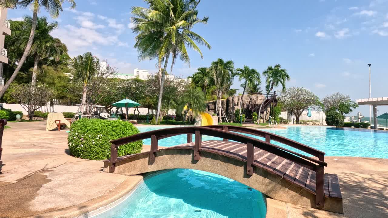 un paseo tranquilo junto a una piscina de un complejo tropical.