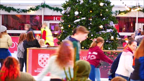 people ice skating around a christmas tree at a festive ice rink in winchester