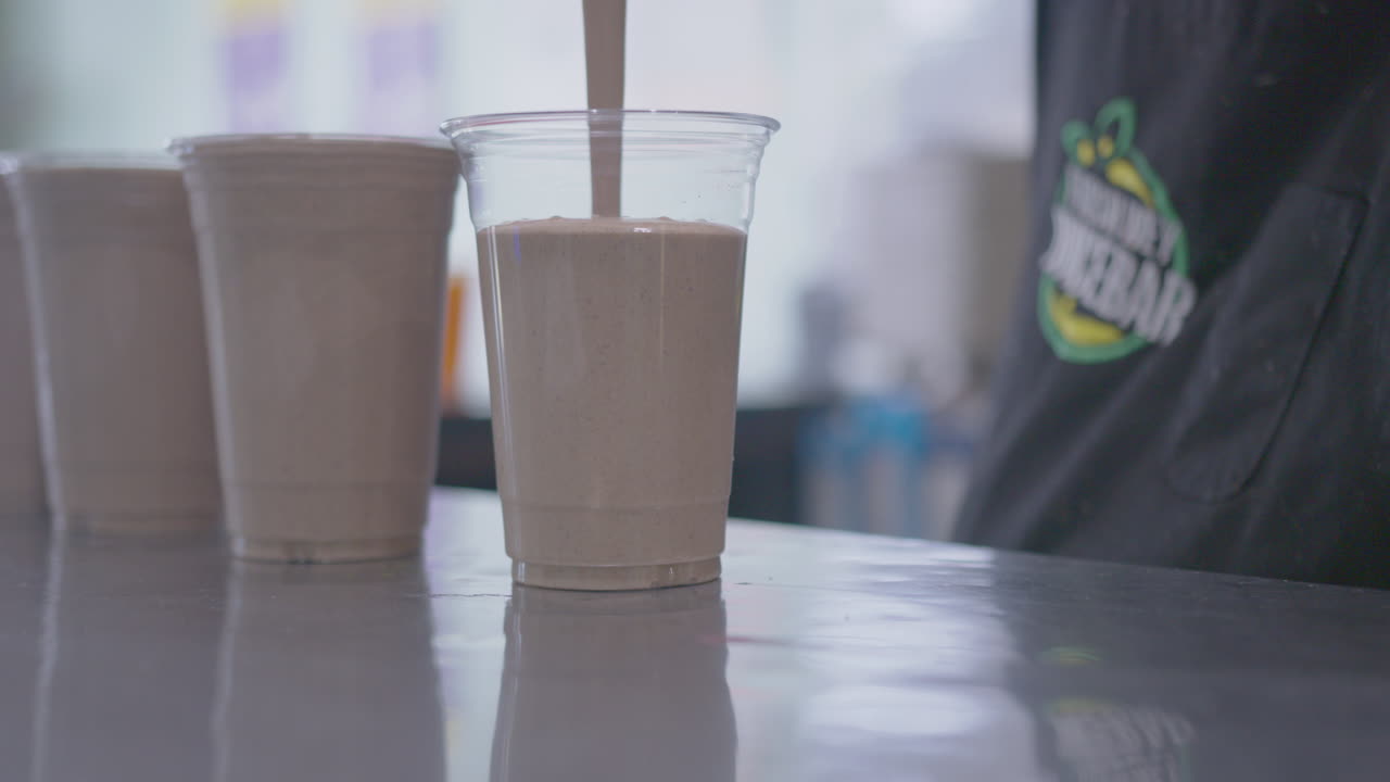 cerca de un batido de proteínas que se vierte en una taza