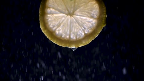 a fresh lemon slice isolated on black with mist at 200 fps slow motion