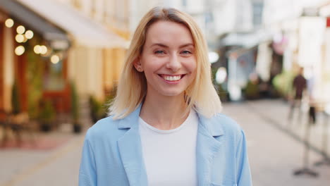 Happy-blonde-woman-smiling-looking-away-dreaming-resting-good-news-feel-satisfied-on-city-street