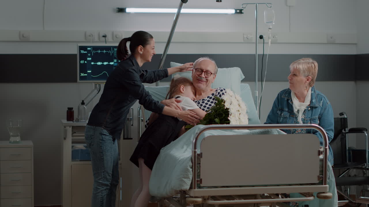 Aged man enjoying visit from daughter and niece in hospital ward
