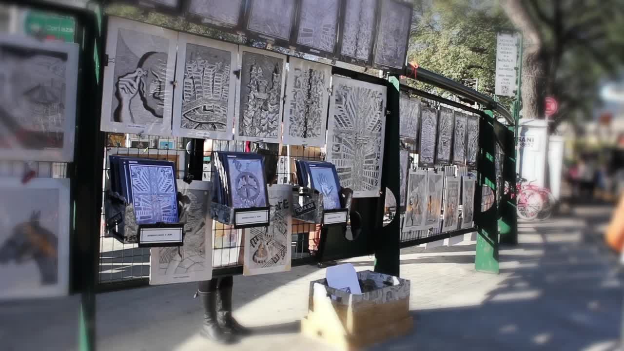 さまざまな版画やデッサンが展示された屋外のアートマーケットの屋台。