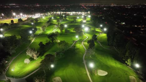 Video-Aéreo-De-Un-Campo-De-Golf-Iluminado-Por-La-Noche.