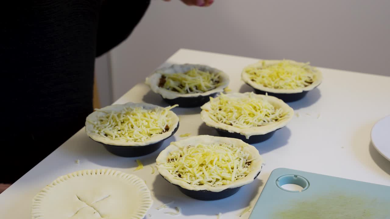 Homemade savory pies being prepared with pastry and cheese in a modern kitchen, showing fresh ingredients, cooking steps, and food preparation from scratch for delicious home baking