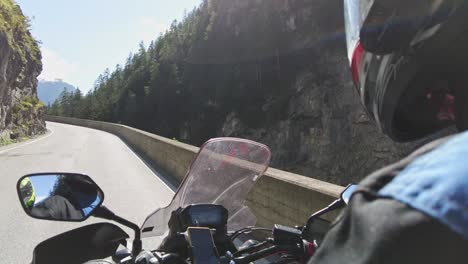 pov biker rides on motorbike by scenic green mountain road, swiss alp, moto trip