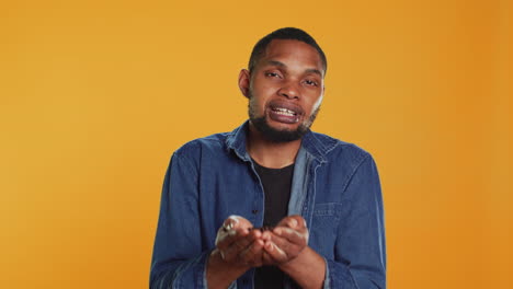 African-american-cheerful-guy-posing-with-black-roasted-coffee-beans