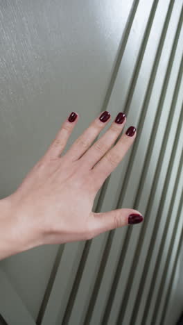 woman's hand with burgundy nails