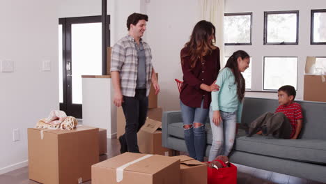 Family-Carrying-Removal-Boxes-Into-New-Home-On-Moving-Day