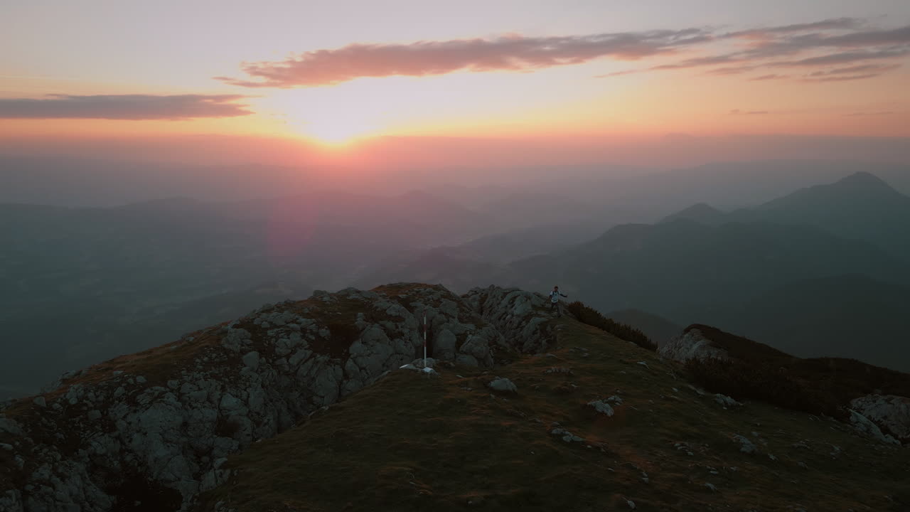 disparo de dron de distanciarlo de la cima de la montaña peca temprano en la mañana con un amanecer naranja