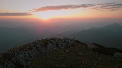 disparo de dron de distanciarlo de la cima de la montaña peca temprano en la mañana con un amanecer naranja