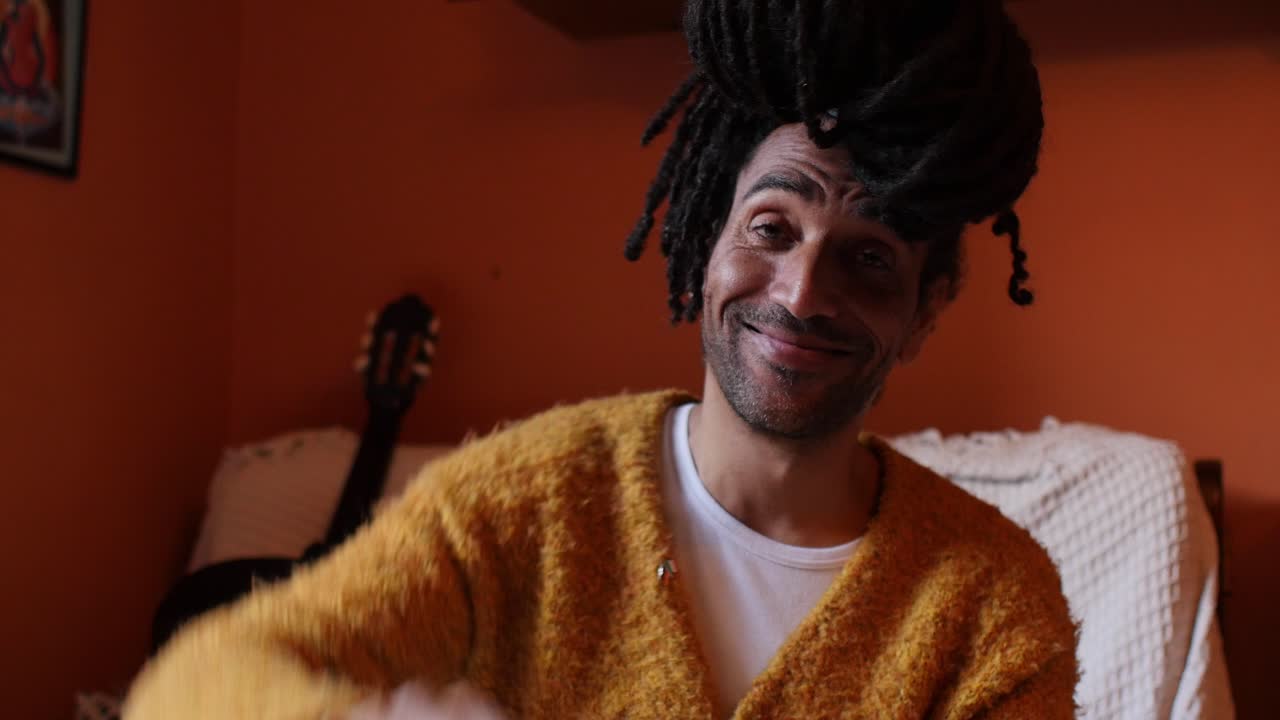 hombre emocionado dando pulgares hacia arriba y realizando un gesto de victoria en la escena de la sala de estar colorida