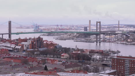 Panoramic-aerial-riser-reveals-Älvsborg-bridge-over-Göta-älv-river,-Gothenburg