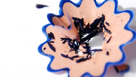 blue color pencil shavings in a flower shape on a white background