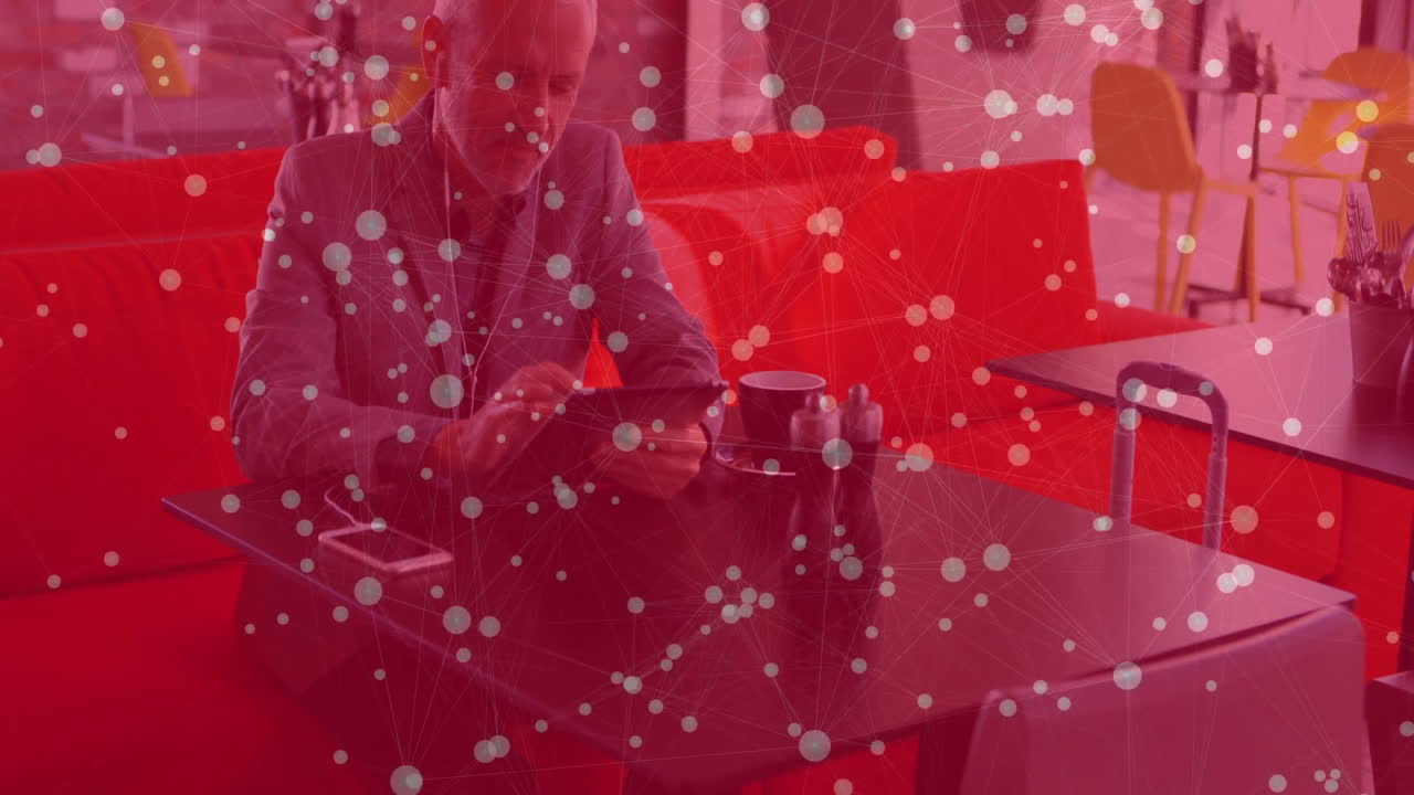 mature male tapping tablet in cafe lounge, displaying animated finance graphs floating above screen