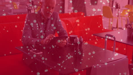 mature male tapping tablet in cafe lounge, displaying animated finance graphs floating above screen
