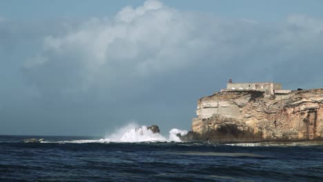 vavas gigantes golpean las rocas del faro en nazaret-portugal
