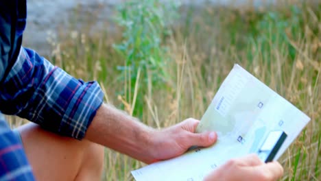 excursionista masculino con un mapa y equipo de orientación en el bosque 4k
