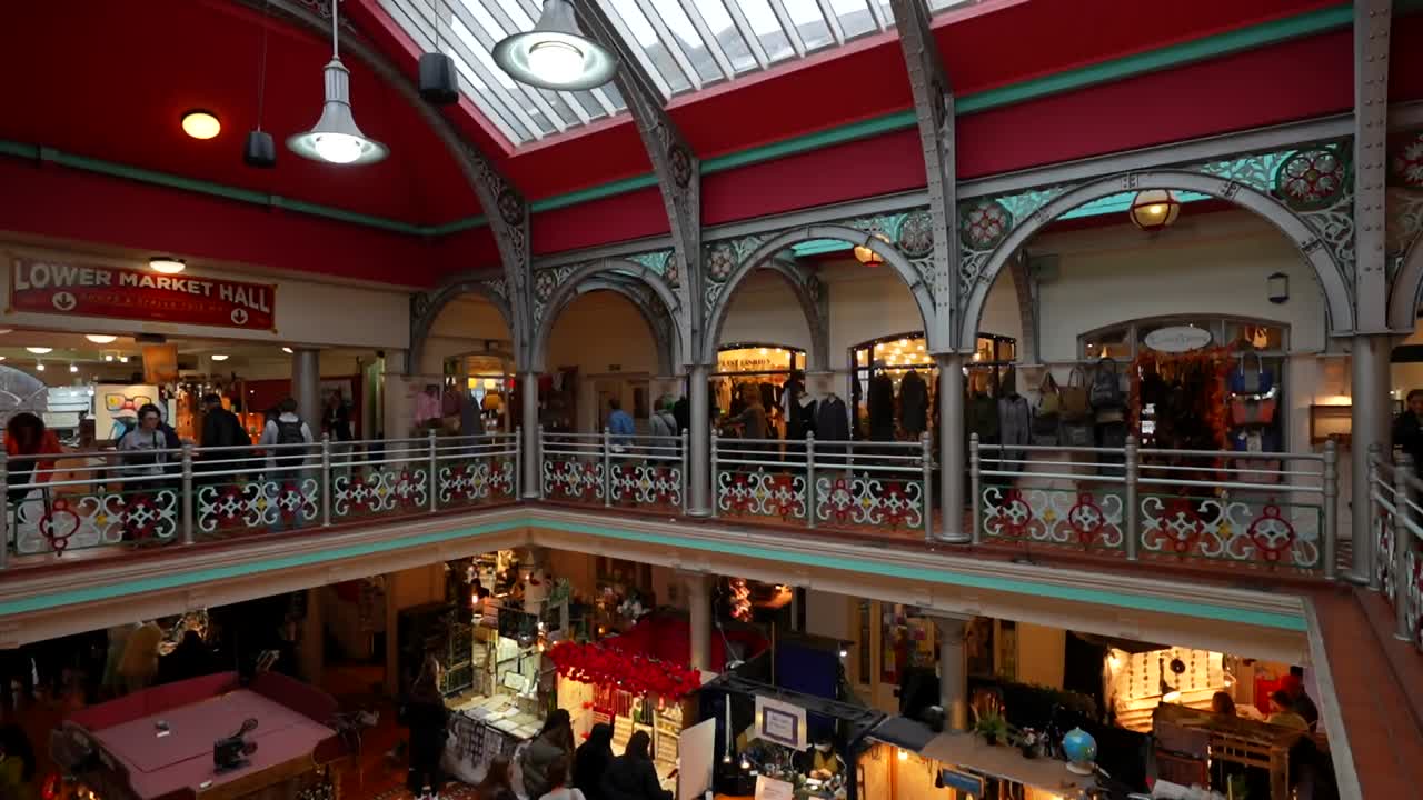 Bustling indoor market in Camden Town with vibrant stalls and shoppers, London. Tilt-down shot