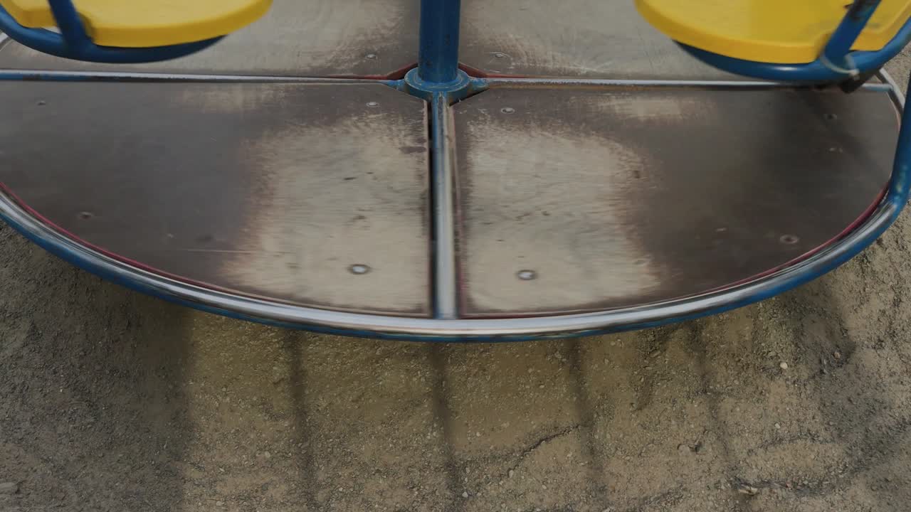 круговая веселка кружится на пустой игровой площадке со своей теней