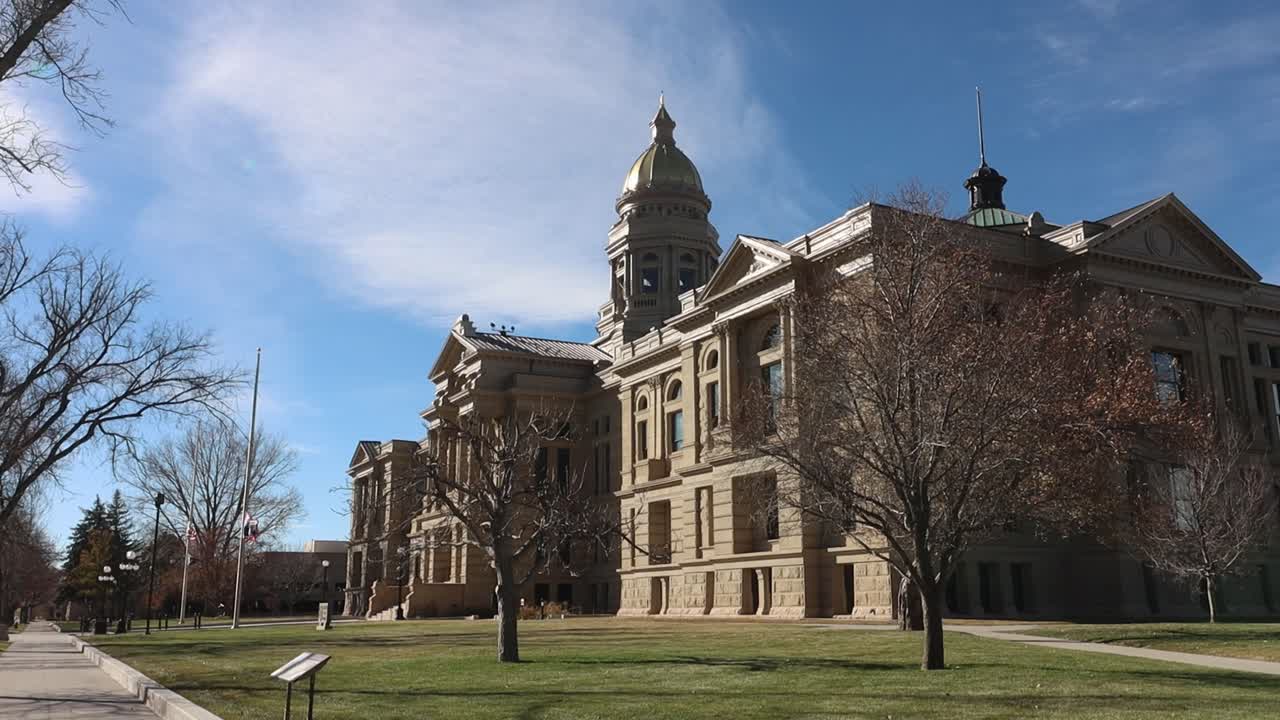 Wyoming State Capital building flags flying half mast in heavy wind