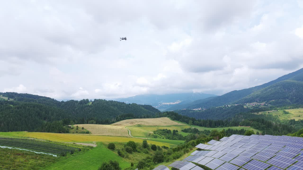 Industrial drone flying over solar panel farm on green hillside, renewable energy and modern technology in rural mountain landscape, Roana, Italy. Aerial