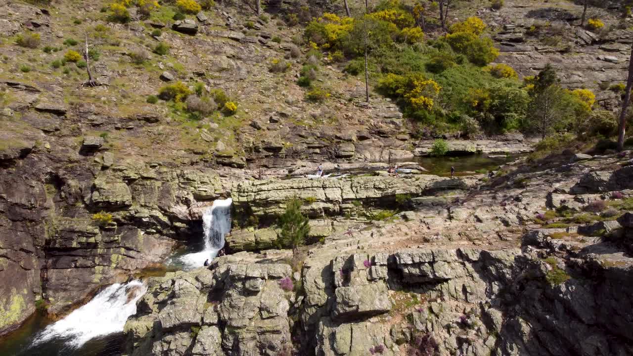 turistas y excursionistas disfrutan del día en cascata de fisgas do ermelo - hermosas cascadas en el parque natural do alvao - portugal