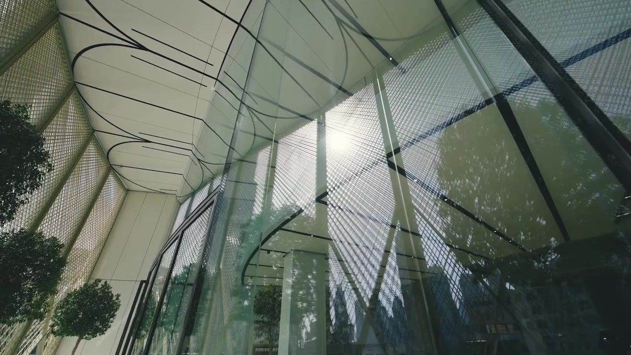 Fotografia de baixo ângulo de edifícios modernos de vidro e verde com fundo de céu claro