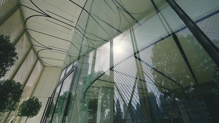 Scatto ad angolo basso di moderni edifici in vetro e verde con sfondo cielo limpido