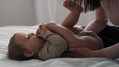 video de una niña caucásica jugando con su mamá en la cama.