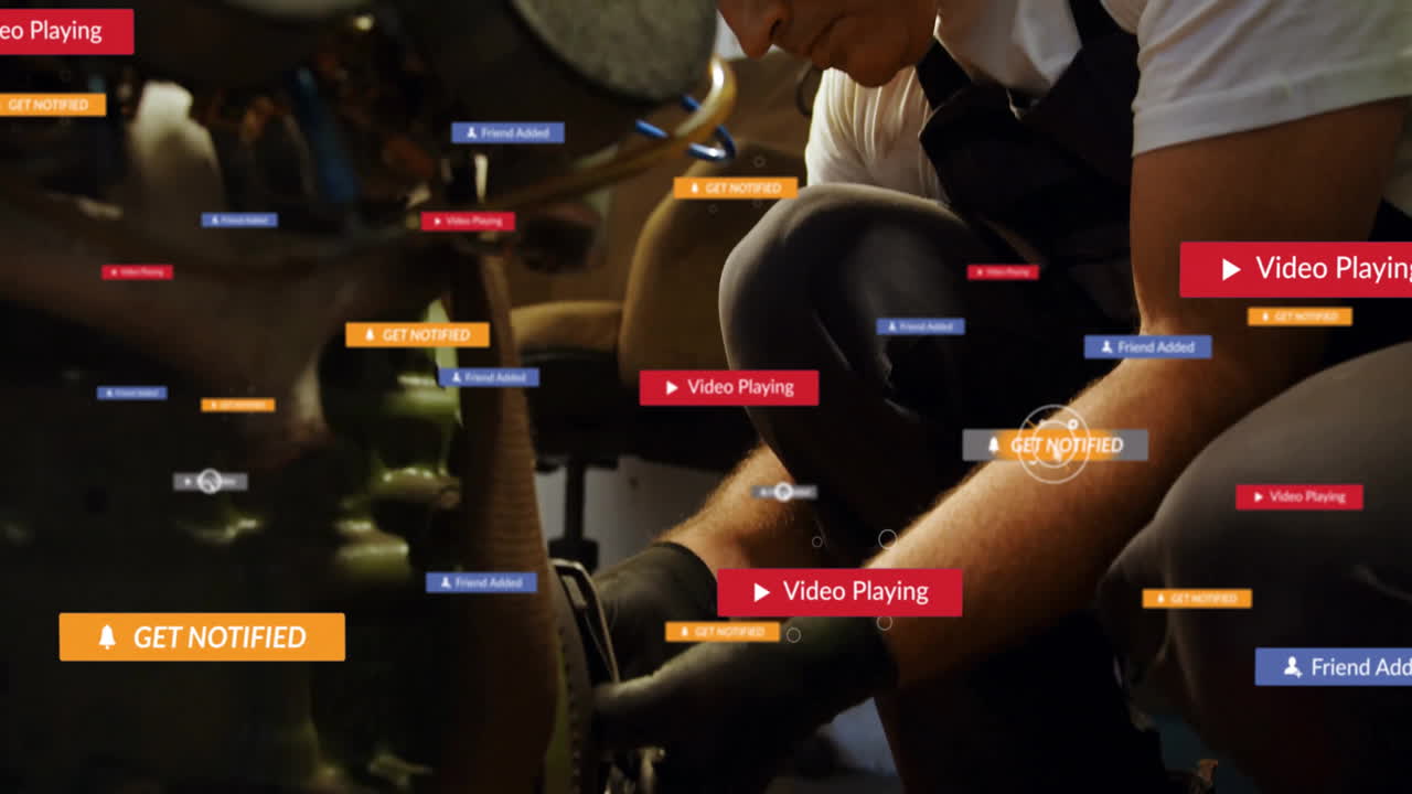 Male mechanic kneeling beside engine in workshop, tightening bolt with floating UI notifications