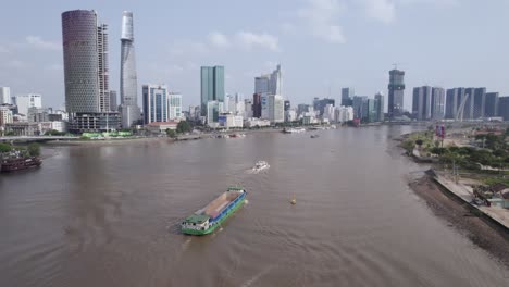 vista de un río con un buque contenedor de transporte de mercancías logístico y la moderna ciudad de ho chi minh de vietnam en el fondo