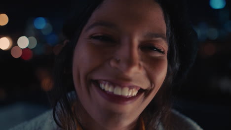 close up portrait funny mixed race woman on rooftop at night making faces enjoying urban nightlife with bokeh city lights in background