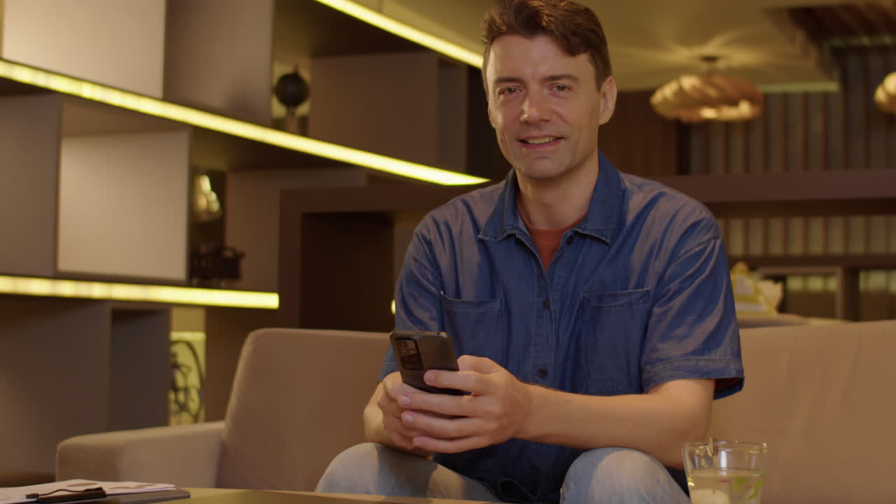 Cheerful Caucasian Businessman Working on Smartphone in Workspace