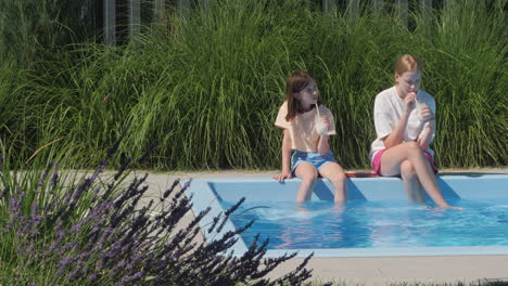 girls enjoying drinks by the pool