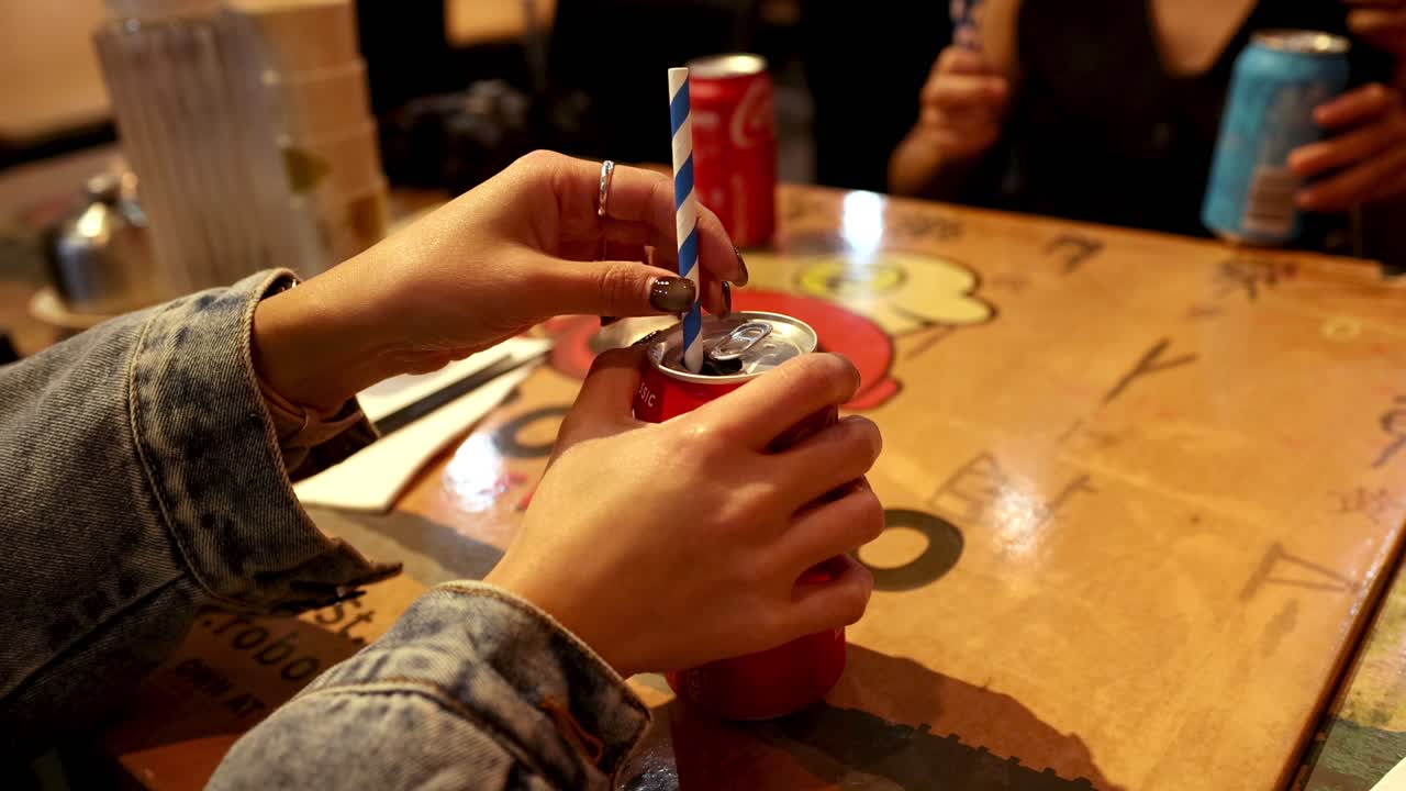 insertando la paja a mano en la lata de cola