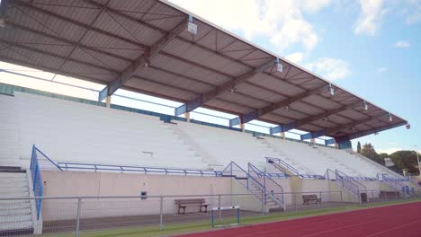 empty seats in a stadium during the covid-19 pandemic, sport activities cancelled during coronavirus lockdown on a sunny day with blue sky