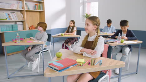 multiethnic group of kids in classroom taking english class at school