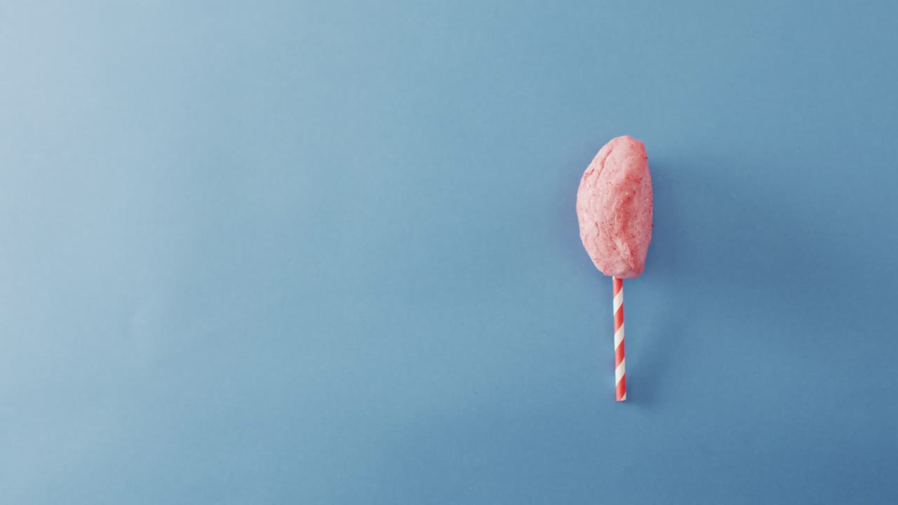 video de malvavisco en un palo que se encuentra en una superficie azul