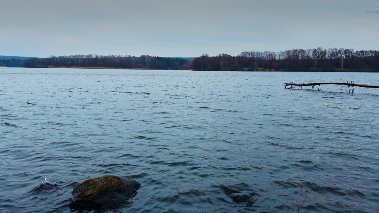 View of the river with uneven surface on winter day. Grey autumn weather in the nature.