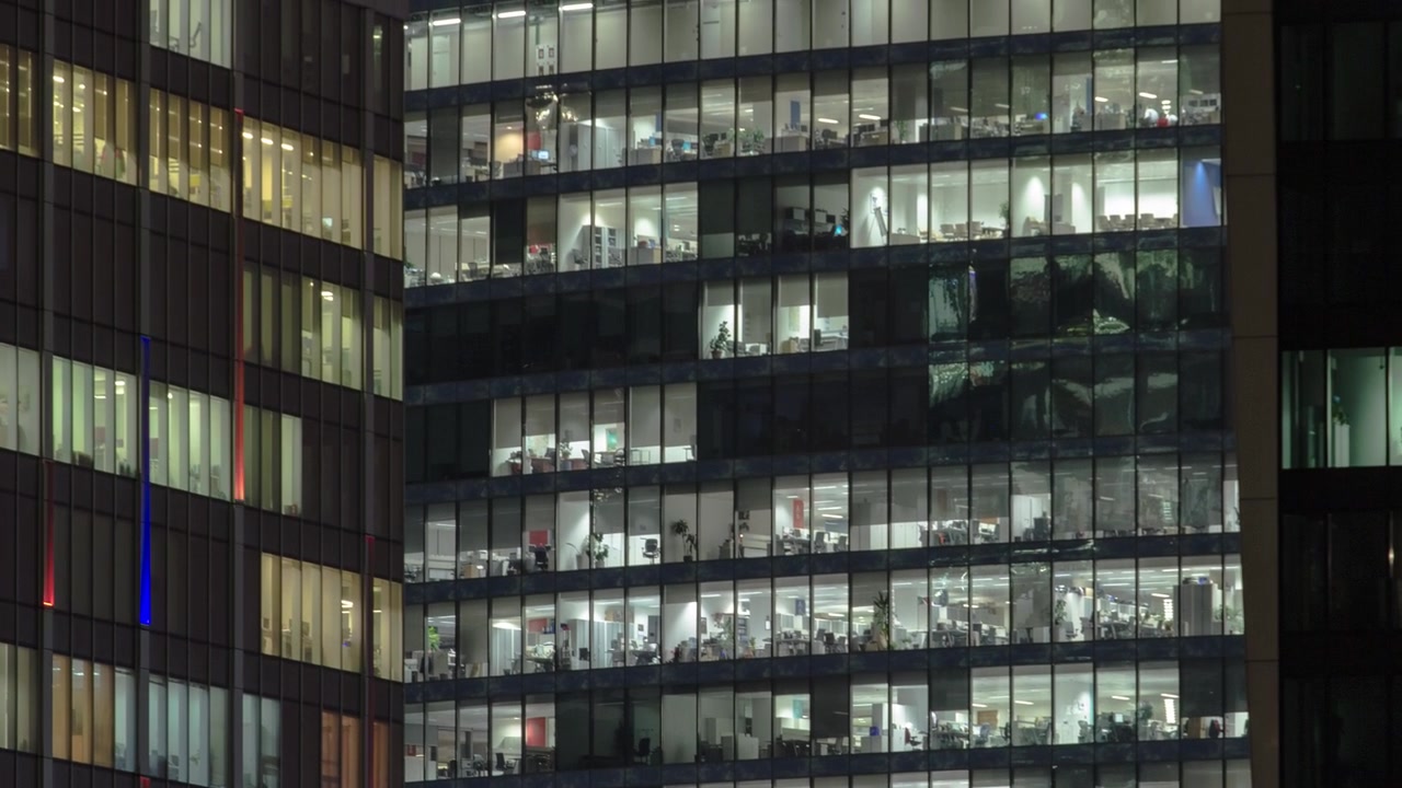 Vista de perto das janelas de escritórios nos arranha-céus do International Business Center City à noite, timelapse do alto.