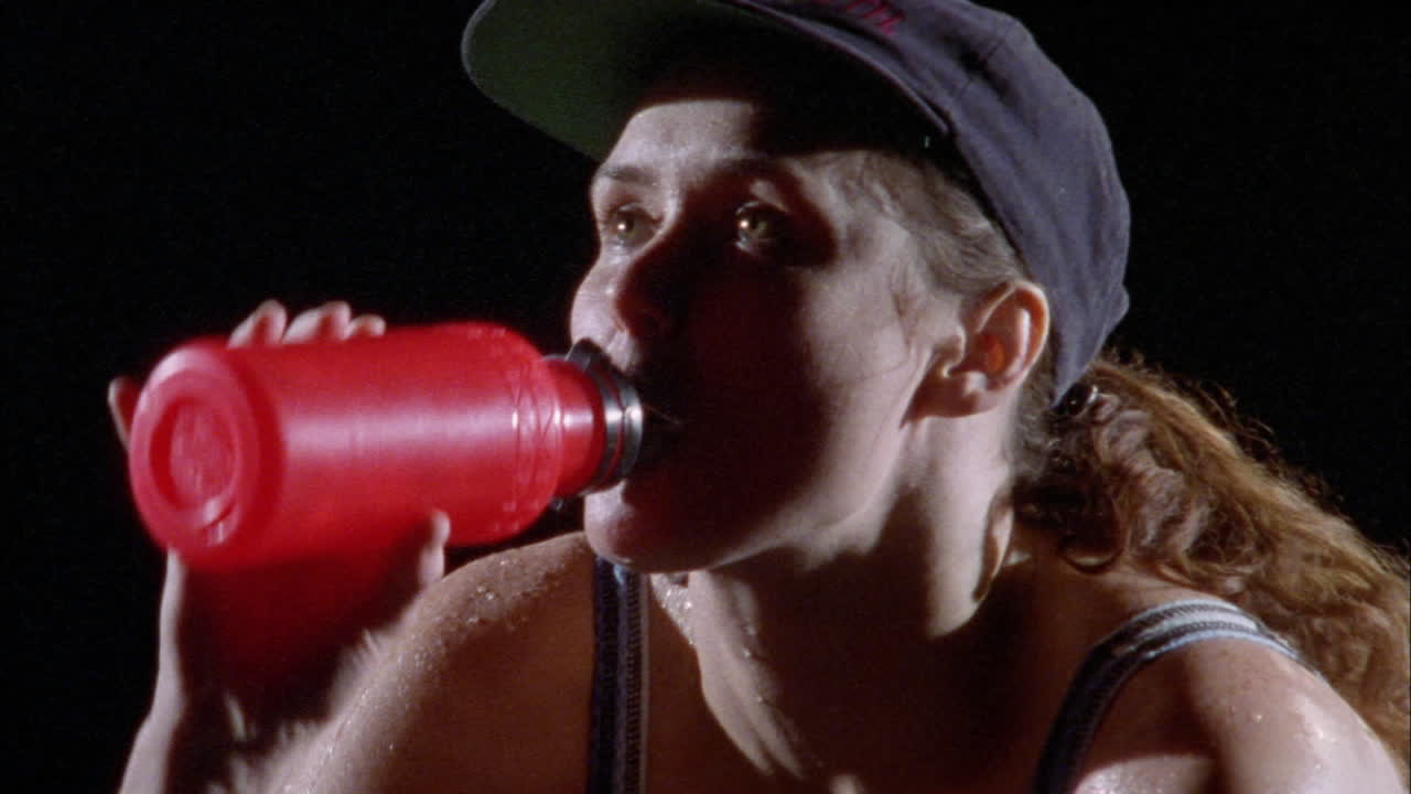 un atleta sediento toma un trago de su botella de agua