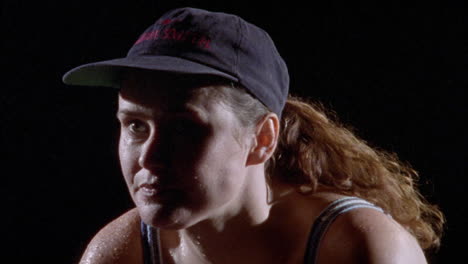 a thirsty athlete takes a drink from her water bottle