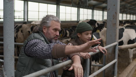 man and boy chatting inside dairy farm facility