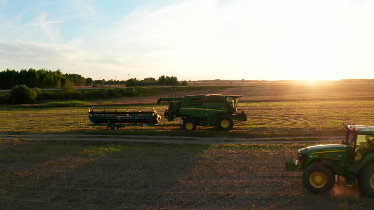 다른 사람이 근처를 지나가는 동안 들판에 서있는 농업 기계