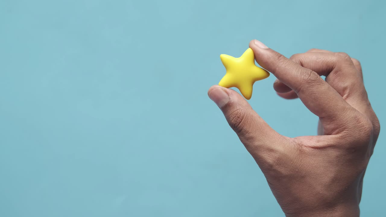 Hand Holding a Yellow Star