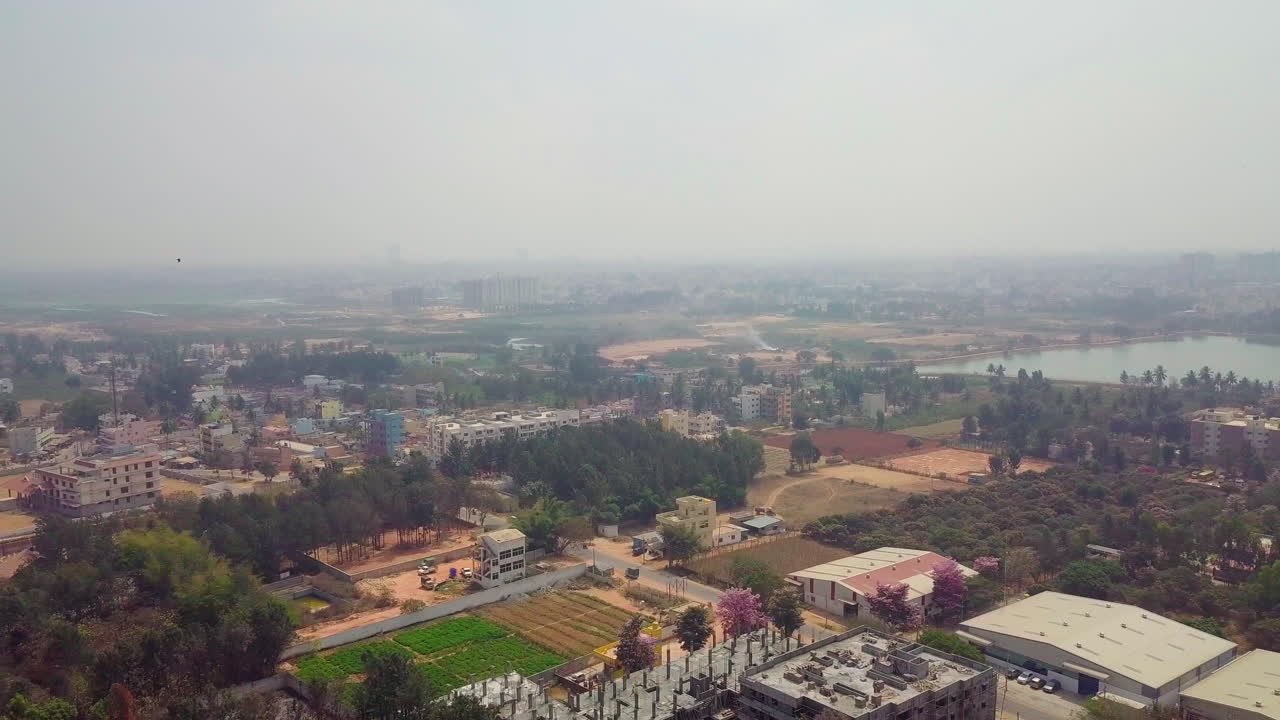 Moving drone view of Bangalore city with Kalkere Lake at a distance in Karnataka, India. 4k.