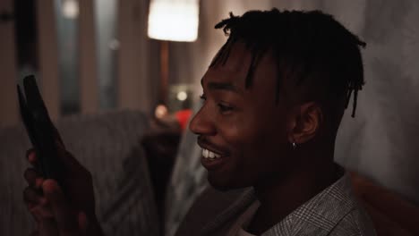 Young-black-male-laughs-while-watching-his-tablet-device