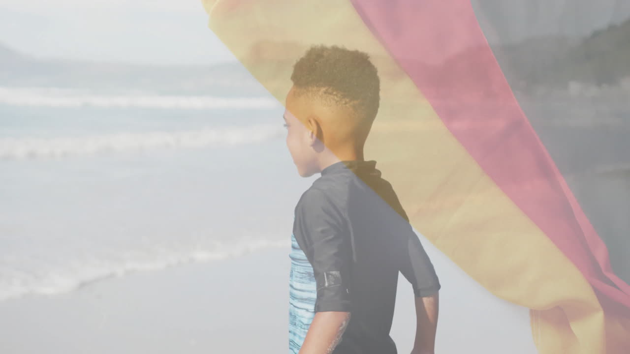 At beach, child with German flag animation overlay in background