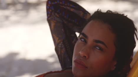 latin brunette pretty girl rests on caribbean beach with captivating smile, closeup tilt